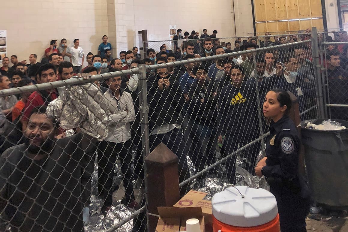 People held behind chain-link fencing and wrapped in mylar blankets at a U.S. detention center in McAllen, Texas.