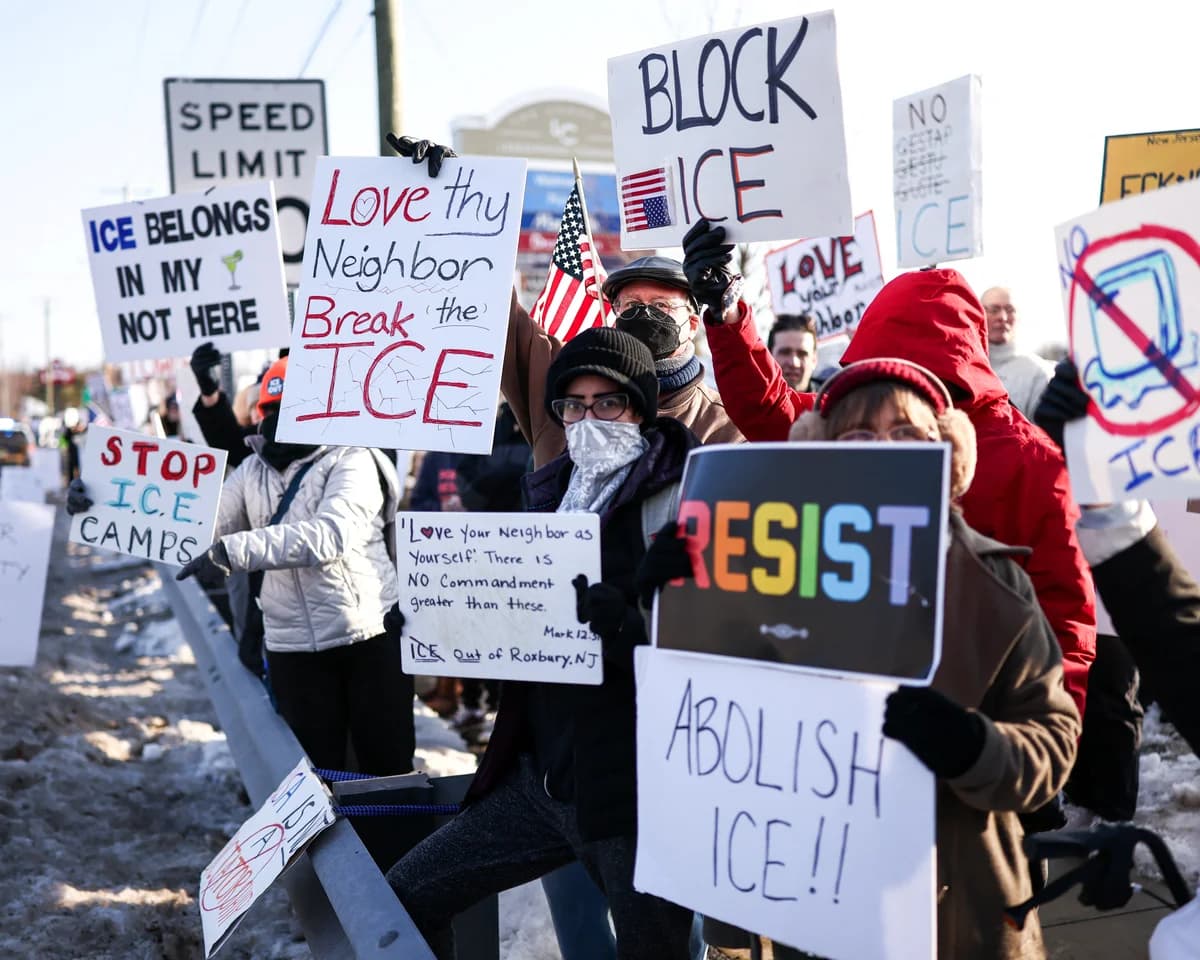 Winter protest with signs reading 'Block ICE,' 'Love thy neighbor, break the ICE,' and 'Abolish ICE.'