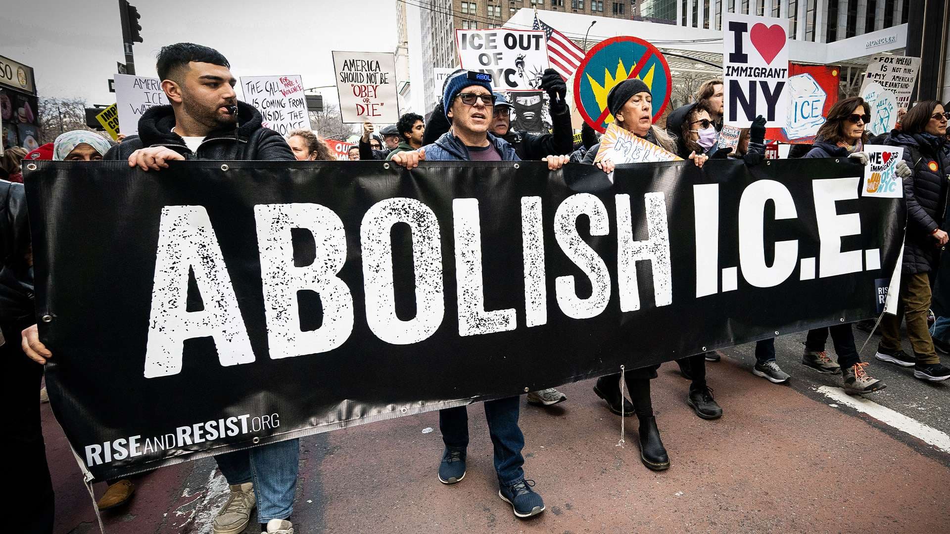 Rise and Resist march in New York City behind a giant 'Abolish I.C.E.' banner.