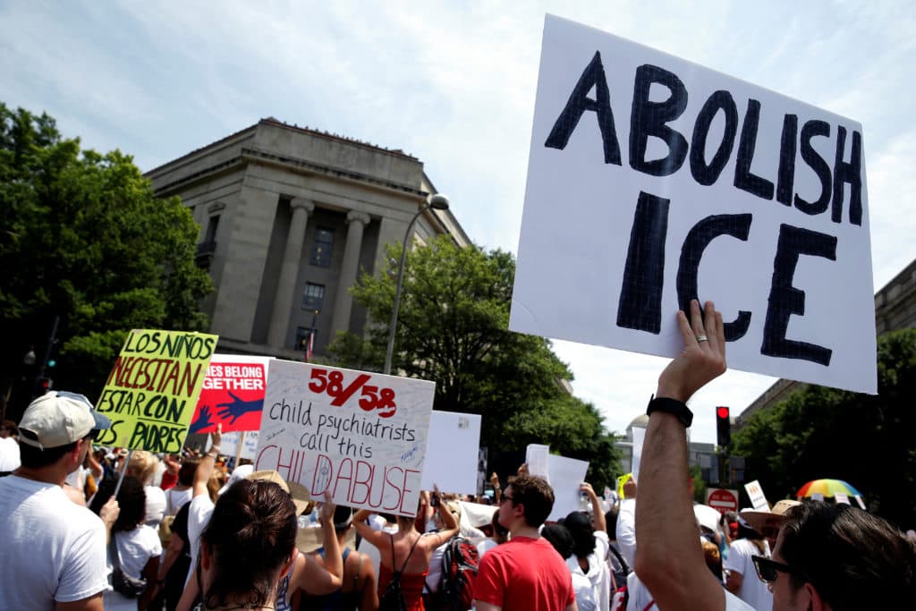 Washington D.C. rally with 'Abolish ICE' and 'Child psychiatrists call this child abuse' signs.